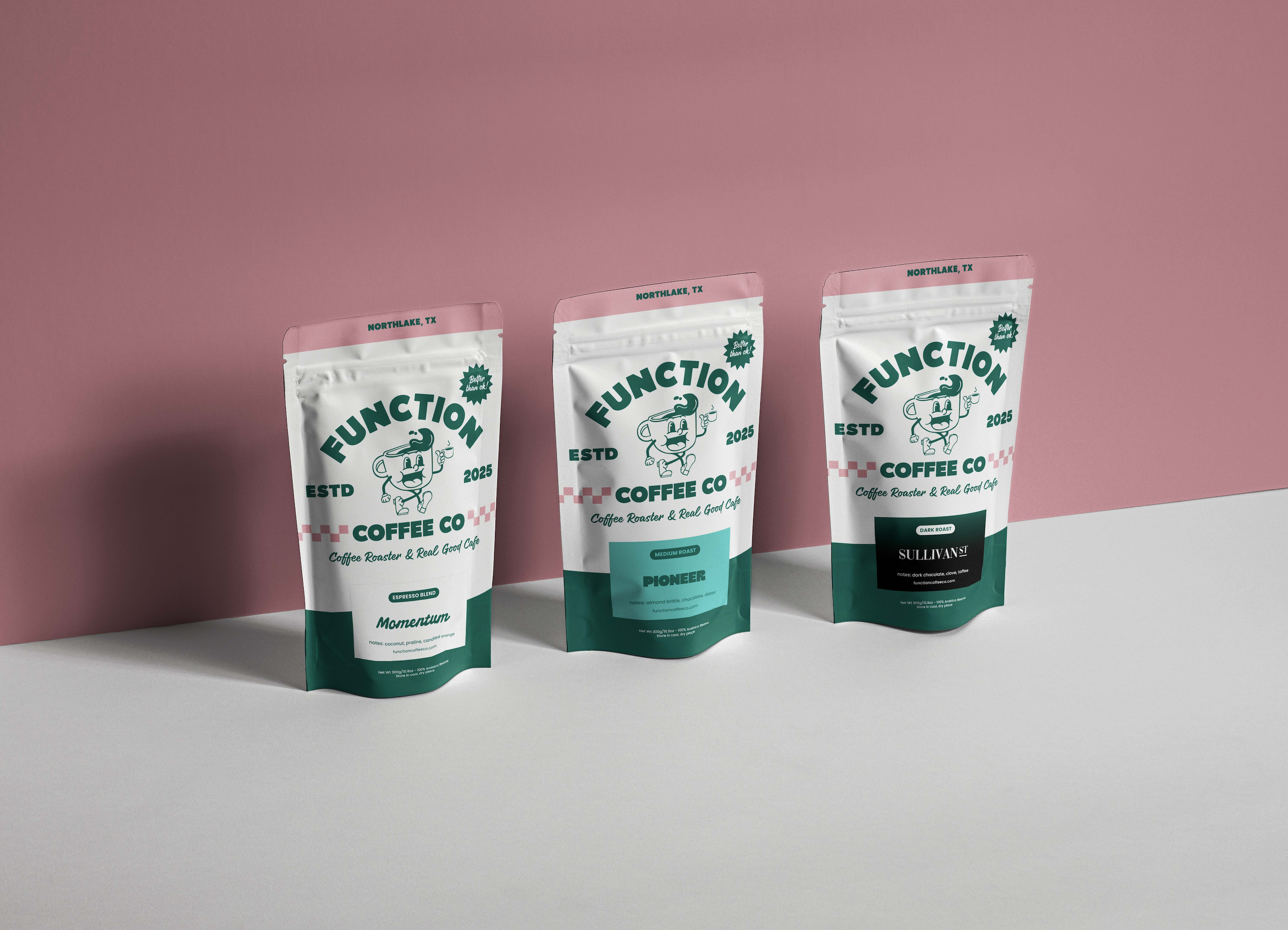 Three Function Coffee Co. coffee bags on a white surface with a pink background