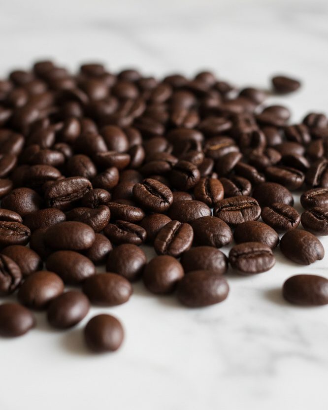 Roasted coffee beans on a white marble surface